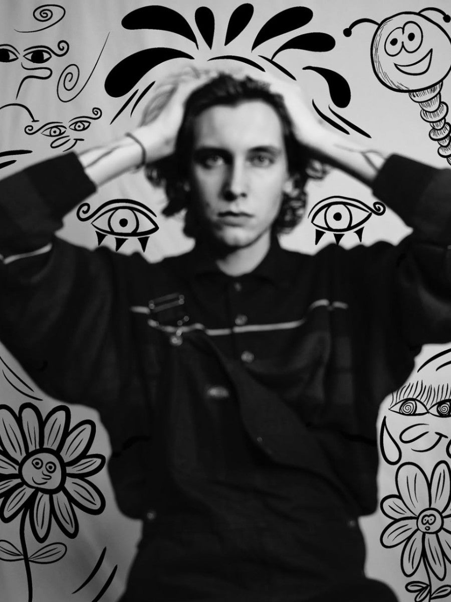 Robin Vandersteen in front of a wall of his ink drawings